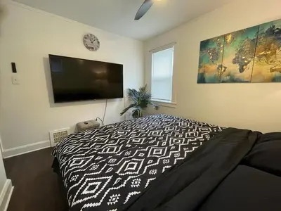 a bedroom with a bed and a flat screen tv at Duplex home away from home in Parma