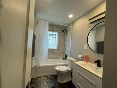 a bathroom with a tub and a toilet and a sink at Duplex home away from home in Parma