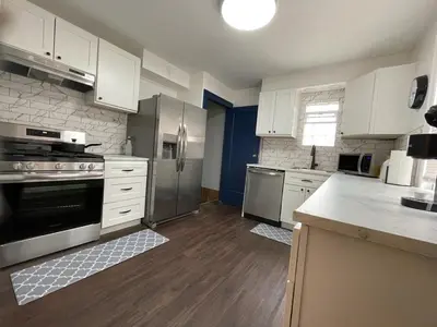 a kitchen with white cabinets and stainless steel appliances at Duplex home away from home in Parma