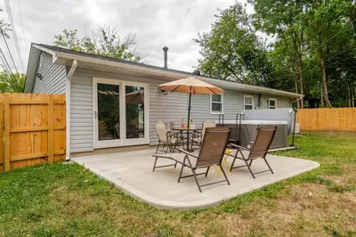 a patio with a table and chairs and an umbrella at Private Ranch- Entire Home - Hot Tub - Pets & Kids Welcome - King Bed - Fenced Backyard - Free WiFi in Gahanna