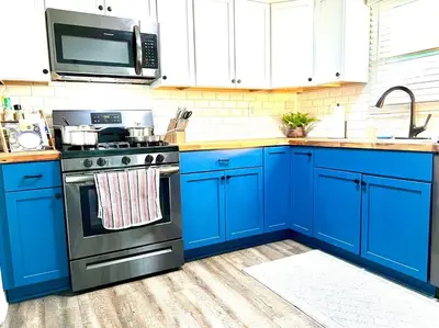 a kitchen with blue cabinets and a stove at Private Ranch- Entire Home - Hot Tub - Pets & Kids Welcome - King Bed - Fenced Backyard - Free WiFi in Gahanna