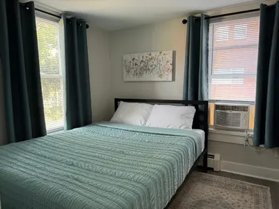 a bedroom with a bed and two windows at Downtown Willoughby Historic District Gem #2 in Willoughby