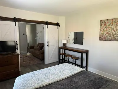 a bedroom with a bed and a television and a couch at Downtown Willoughby Historic District Gem #2 in Willoughby