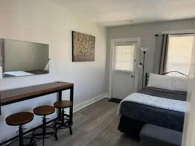 a bedroom with a bed and a desk with a mirror at Downtown Willoughby Historic District Gem #2 in Willoughby