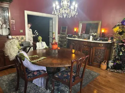a dining room with a table and a mirror at Main Oak Manor in Gallipolis