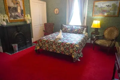 a bedroom with a bed with a vase on it at Main Oak Manor in Gallipolis