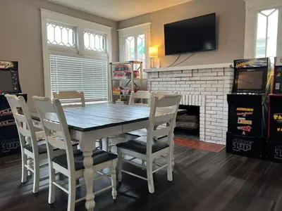 a dining room with a table and chairs and a fireplace at House with 10 Beds Sleeps 16 free Driveway Parking in Cincinnati