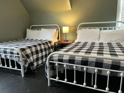 two beds sitting next to each other in a room at House with 10 Beds Sleeps 16 free Driveway Parking in Cincinnati