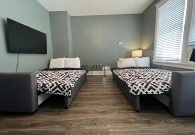 a room with two beds and a flat screen tv at House with 10 Beds Sleeps 16 free Driveway Parking in Cincinnati