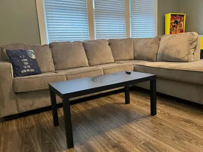 a brown couch with a coffee table in a living room at House with 10 Beds Sleeps 16 free Driveway Parking in Cincinnati