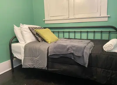 a bed with pillows on it in a room at House with 11 Beds Sleeps 14 with Off Street Parking in Akron