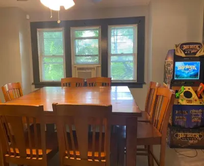 a dining room with a wooden table and chairs at House with 11 Beds Sleeps 14 with Off Street Parking in Akron