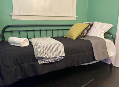 a bed with blankets and pillows on top of it at House with 11 Beds Sleeps 14 with Off Street Parking in Akron