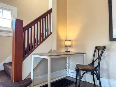 a desk with a lamp and a chair next to a staircase at Spacious 3 Bedroom Sleeps 12 with 7 Beds plus Parking in Dayton