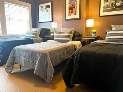 a bedroom with two beds with pillows and a couch at 3 Bedroom House, 7 Beds, Sleeps 10, Dayton in Dayton