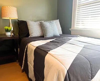 a bedroom with a bed with a lamp on a table at 3 Bedroom House, 7 Beds, Sleeps 10, Dayton in Dayton