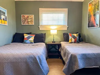 a bedroom with two beds and a table with a lamp at Sleeps up to 20 in Dayton with 6 Bedrooms plus 2 Full Kitchens in Dayton