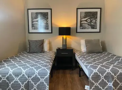 a bedroom with two beds and a lamp on a table at Sleeps 16 with 11 Beds 6 Bedrooms plus WIFI in Dayton