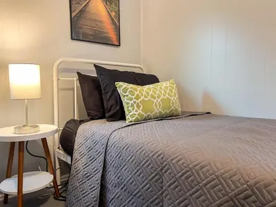 a bedroom with a bed and a table with a lamp at Spacious 4 bedroom Sleeps 8 with 7 Beds plus Parking in Dayton