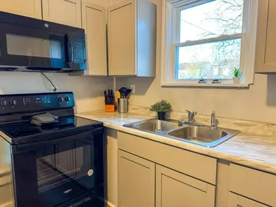 a kitchen with a sink and a stove and a microwave at Spacious 4 bedroom Sleeps 8 with 7 Beds plus Parking in Dayton