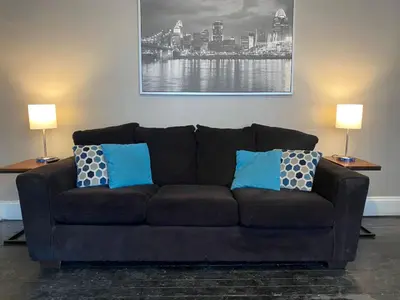 a black couch with blue pillows in a living room at Rare Find Sleeps 16 with 9 Beds 6BR plus WIFI in Cincinnati