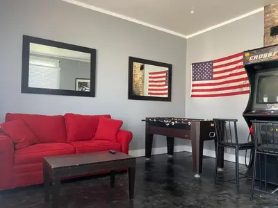 a living room with a red couch and an american flag at Rare Find Sleeps 16 with 9 Beds 6BR plus WIFI in Cincinnati