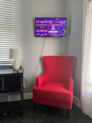 a red chair in a room with a tv on the wall at Rare Find Sleeps 16 with 9 Beds 6BR plus WIFI in Cincinnati