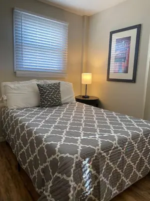 a bedroom with a bed with a gray and white comforter at Crew Housing Sleeps 8 with 6 Beds plus 4 Bedrooms in Dayton
