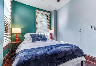 a bedroom with a bed with a blue wall at Downtown Mansion with 7 Bedrooms 2.5 Baths Sleeps 20 in Cincinnati