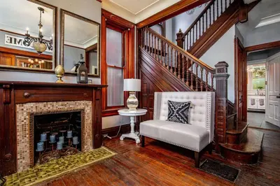 a living room with a fireplace and a chair at Downtown Mansion with 7 Bedrooms 2.5 Baths Sleeps 20 in Cincinnati