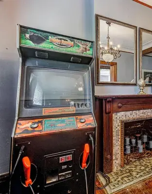 a video game machine in a room with a fireplace at Downtown Mansion with 7 Bedrooms 2.5 Baths Sleeps 20 in Cincinnati