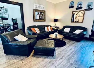 a living room with black leather couches and a table at Downtown Home 10 Beds Sleeps 14 w Parking in Cincinnati