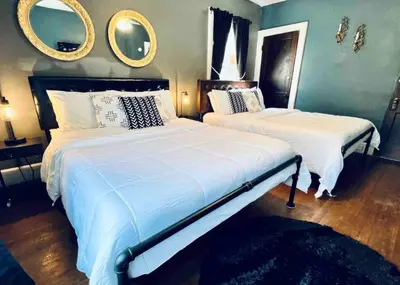 two beds in a bedroom with two mirrors on the wall at Downtown Home 10 Beds Sleeps 14 w Parking in Cincinnati