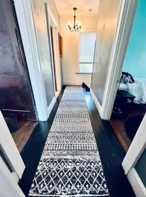 a hallway with a black and white rug and a chandelier at Downtown Home 10 Beds Sleeps 14 w Parking in Cincinnati