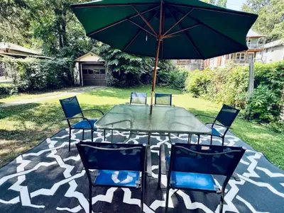 a table with chairs and an umbrella on a patio at Downtown Home 10 Beds Sleeps 14 w Parking in Cincinnati