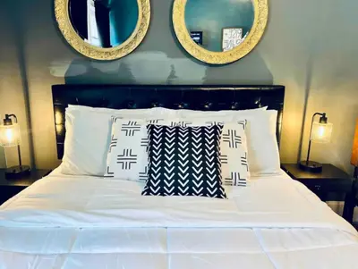 a bedroom with a white bed with two mirrors at Downtown Home 10 Beds Sleeps 14 w Parking in Cincinnati