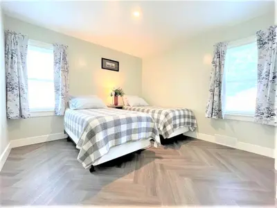two beds in a room with two windows at Walnut - Family Neighborhood, Pet Friendly in Paulding