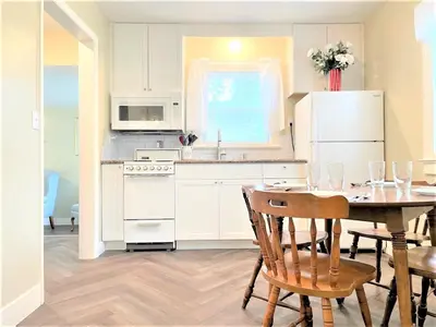 a kitchen with a table and a white refrigerator at Walnut - Family Neighborhood, Pet Friendly in Paulding