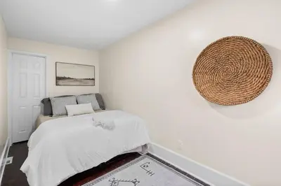 a white bedroom with a bed and a basket on the wall at Charming Home in Cleveland 3215 in Ohio City