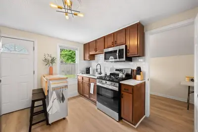 a kitchen with wooden cabinets and a black stove top oven at Charming Home in Cleveland 3215 in Ohio City