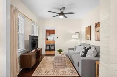 a living room with a gray couch and a ceiling fan at Charming Home in Cleveland 3215 in Ohio City