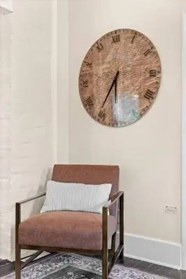 a clock hanging on a wall next to a chair at Charming Home in Cleveland 3215 in Ohio City