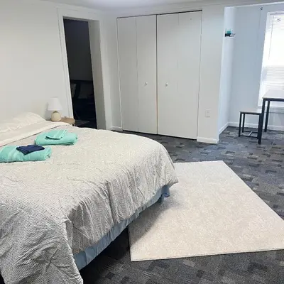 a white bedroom with a bed and a dresser at The Haven in Toledo