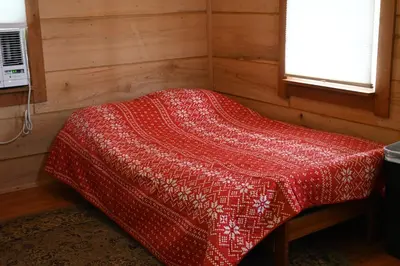 a red blanket on a bed in a room at Cozy Cabin in New Lexington