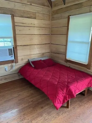 a small room with a red bed in the corner at Cozy Cabin in New Lexington