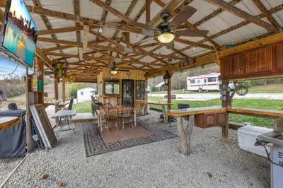 an outside view of a house with a table and chairs at Cozy Cabin in New Lexington