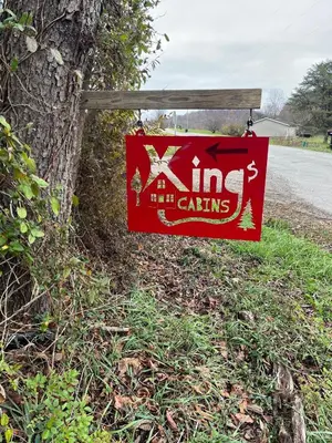 a sign hanging on a fence next to a road at Cozy Cabin in New Lexington