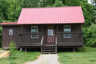 a small wooden house with a red roof at Cozy Cabin in New Lexington