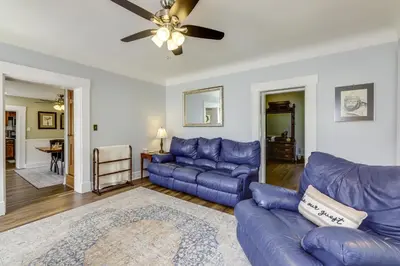 a living room with blue couches and a ceiling fan at Grandma Kellys Southeast Indiana Farmhouse! in Cedar Grove