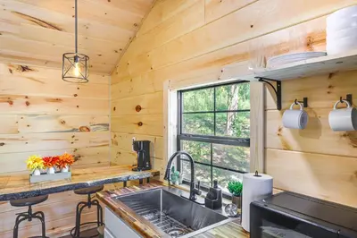 a kitchen with wooden walls and a sink and a window at Stout Cabin with Fire Pit 1 Mi to Ohio River! in Stout